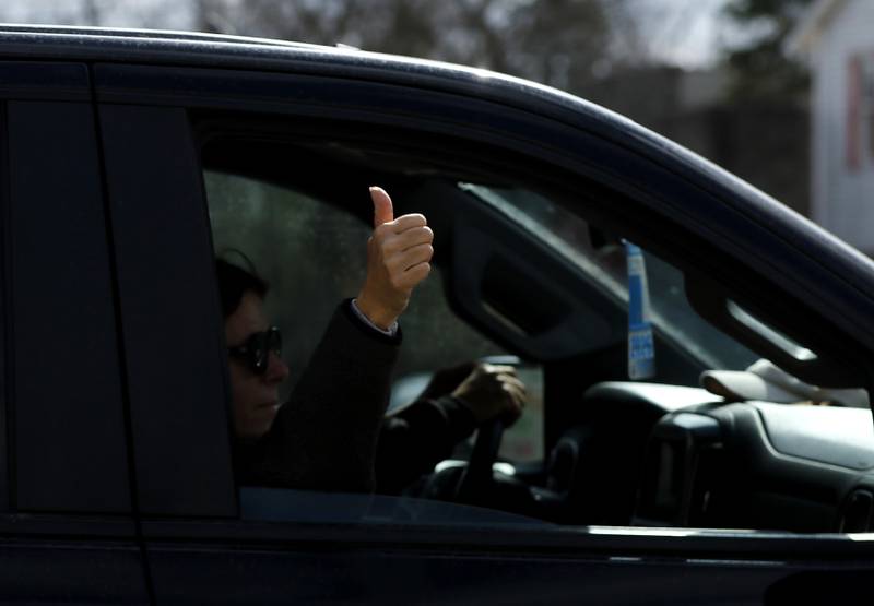 A motorist gives the “thumbs up” to protesters that were lined along U.S. Route 12 in Richmond to protest their discontent with President Donald Trump and his administration's policies on Saturday, April 19, 2025. Over 100, people took part in the Richmond protest. A second rally was held in Harvard later in the day.