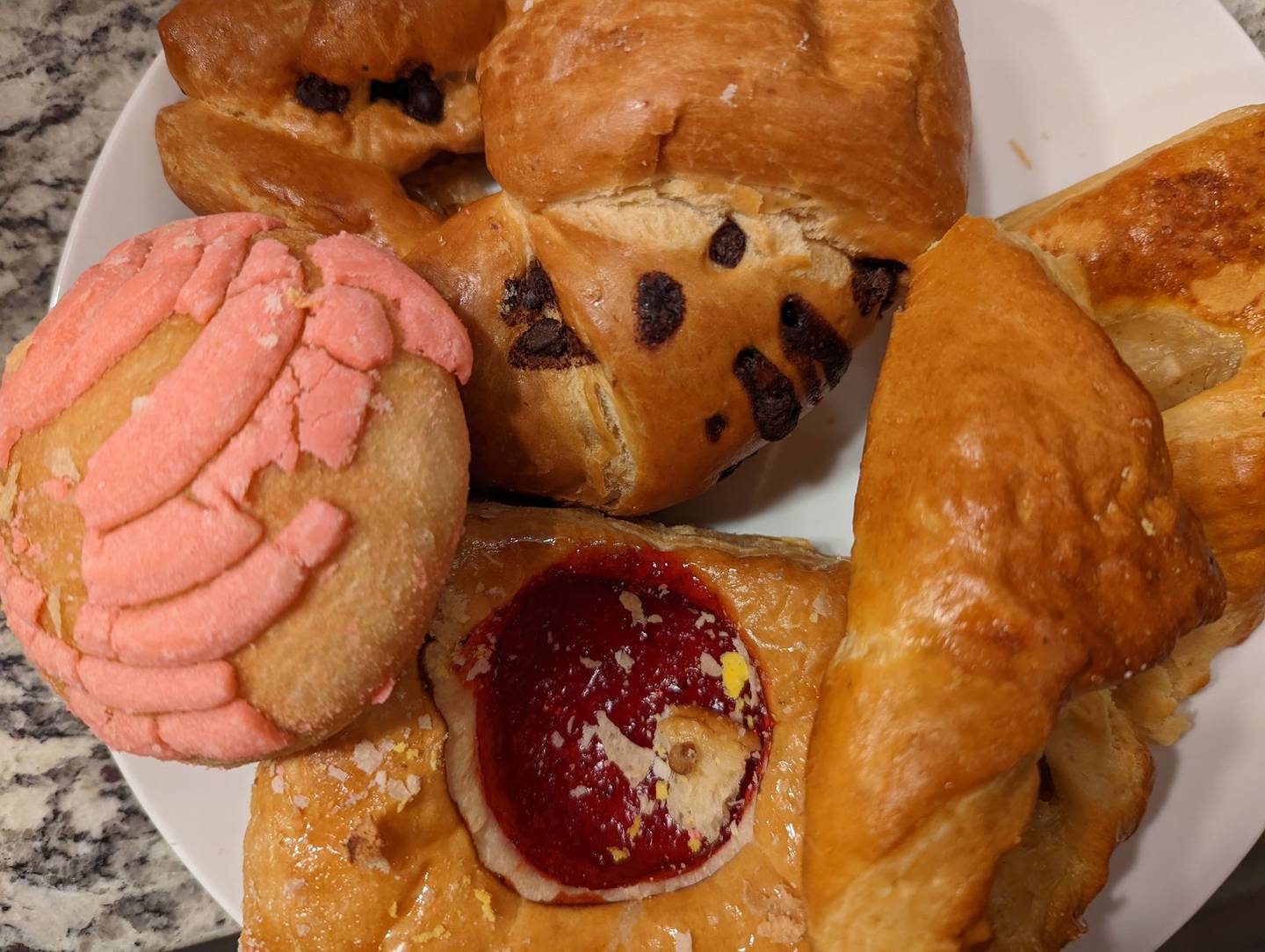 La Chicanita Bakery in Crest Hill offers a wide variety of homemade breads and pastries, juices, sandwiches and custom cakes. The pink-topped item at the left is a concha, a sweet, brioche-like pastry. Also pictured are two fruit danishes and a chocolate croissant.