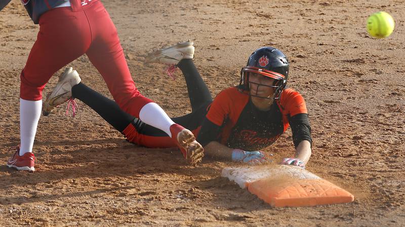 Crystal Lake Central's Liv Shaw dives back into first base as the ball bounces away from Marian Central's Kaylie Kowalsky during a nonconference softball game on Thursday, April 3, 2025, at bates Park in Woodstock.