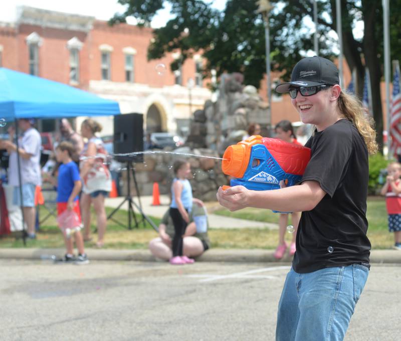 A member of the Blackhawk 4-H Club uses a squirt gun to try and cool down the crowd during the 2023 Let Freedom Ring parade on Tuesday,  July 4.