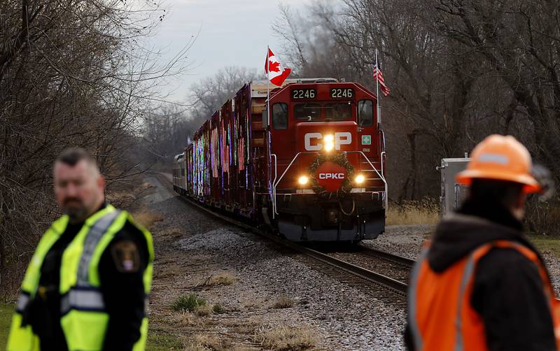 Police and railroad official guard the tracks  on Wednesday Nov. 27, 2024, as the Canadian Pacific Kansas City Railway 2024 Holiday Train pulls into Pingree Grove. The holiday train raised food and monetary donations for the D300 Food Pantry during its stop in Pingree Grove.