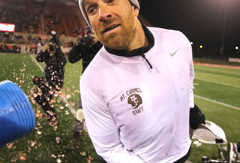 Mt. Carmel Head Coach Jordan Lynch dodges the Gatorade shower as time ticks down in their Class 8A state championship win over Batavia Saturday, Nov. 30, 2024, in Hancock Stadium at Illinois State University in Normal.
