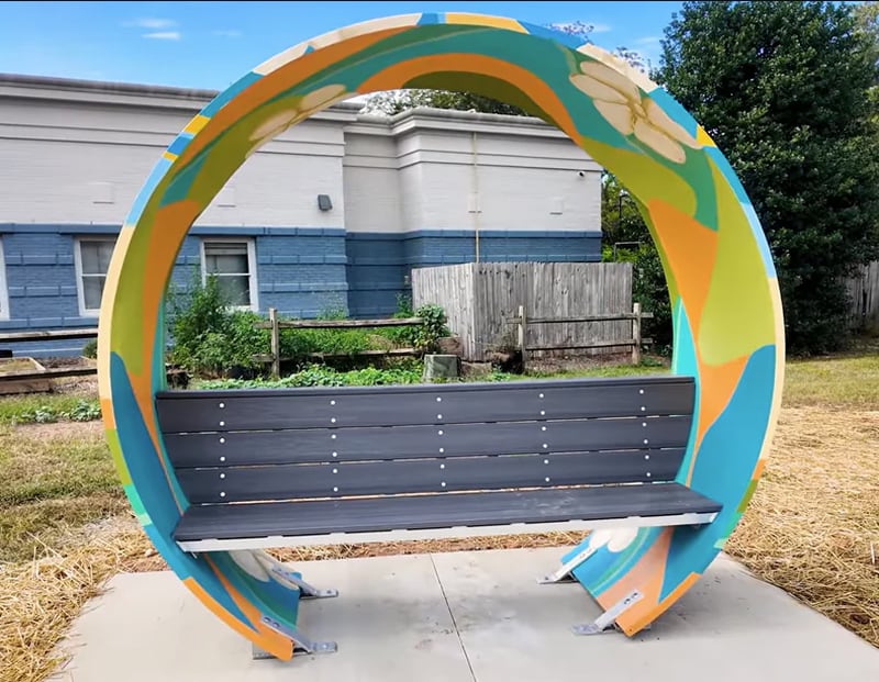 An example of a bench made from upcycled wind turbine blades painted by a muralist.