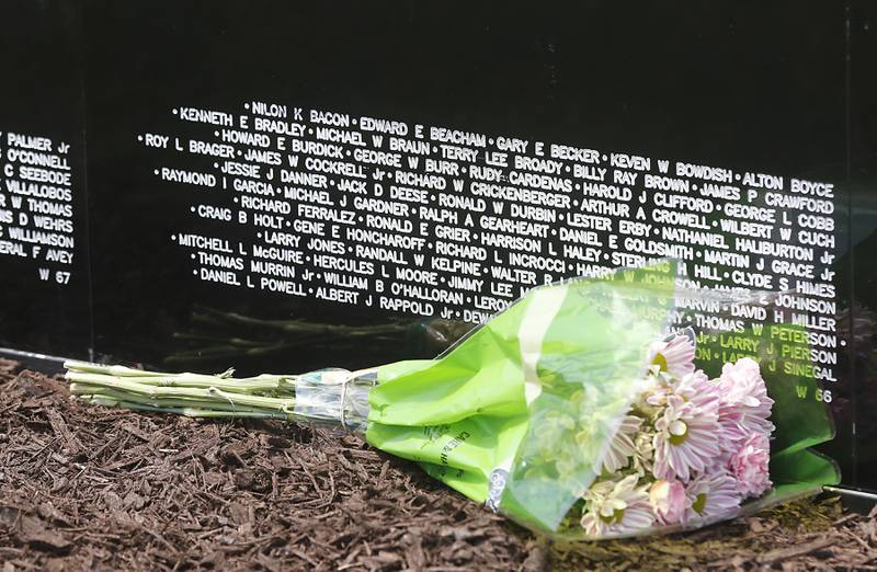 Flowers are left Friday, July 14, 2023, at the Vietnam Traveling Memorial Wall at the VFW Post 4600 in McHenry. The 3/5 scale wall will be at the post and open to the public until Sunday evening and will hold an opening  ceremony at 10 a.m. on Saturday.