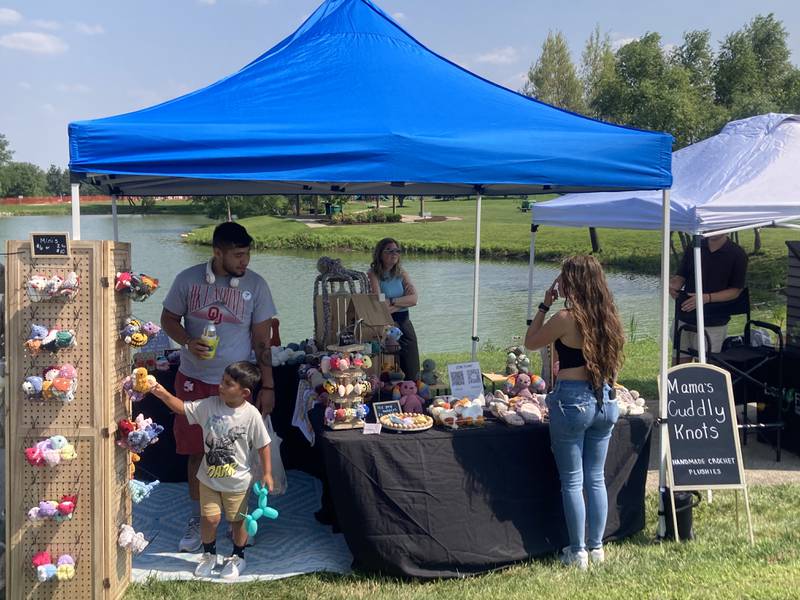 A craft vendor sells crochet toys at the Shorewood Crossroads Festival on Saturday, August 2, 2025.