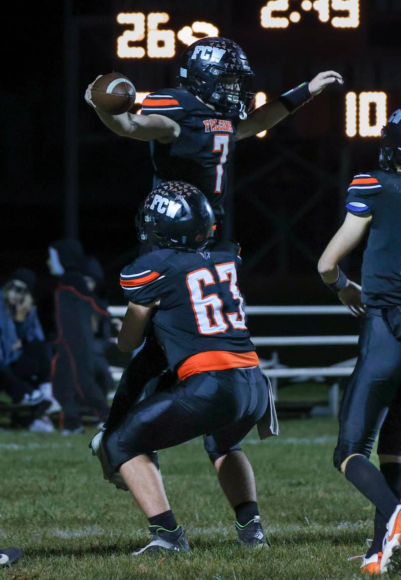 Leelynd Durbin (7) and Aydan Radke (63) of Flanagan-Cornell/Woodland celebrate after a Durbin Week 9 touchdown in Flanagan.