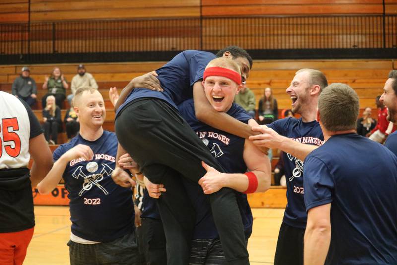 Hayden LaPointe hoists Landen Gadney in the air after he shoots and scores the game-winning the shot at the buzzer Dec. 4, 2023 during the annual Guns and Hoses Basketball Game put on at Huntley Middle School in DeKalb.