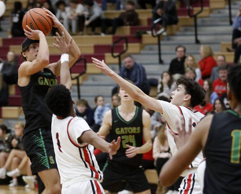 Crystal Lake South's Maddox Stroner shoots the ball over Huntley's Bryce Walker and Christian Wilson during a Fox Valley Conference boys basketball game Tuesday, Feb.6, 2024, at Huntley High School.