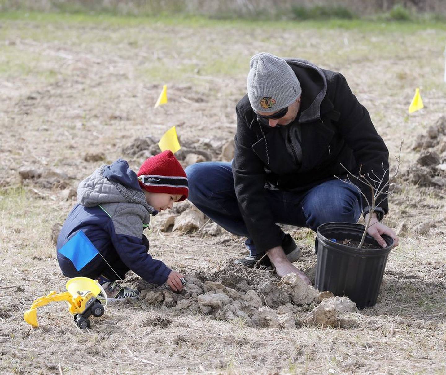 Volunteer Chris Navarro of Geneva and his 3-year-old son Lucas help the Forest Preserve District of Kane County plant trees Saturday. The event, held at Tekakwitha Woods Forest Preserve in St. Charles, was in honor of Earth Day.
