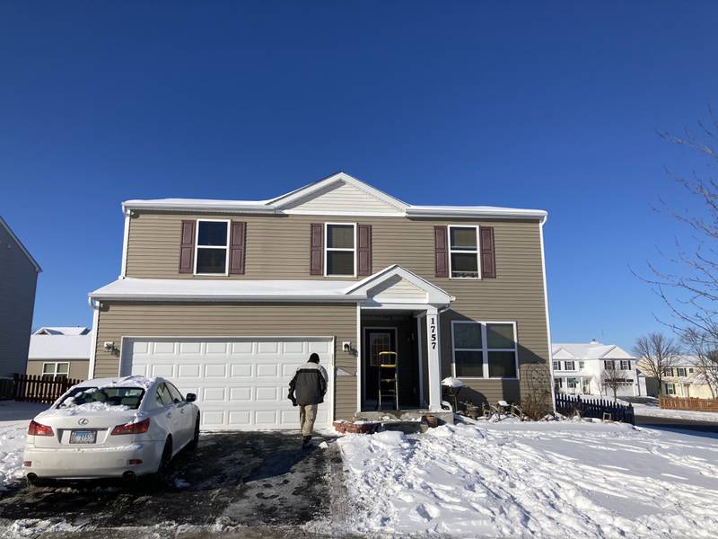 A Woodstock police officer looks for evidence Tuesday, Jan. 25, 2022, outside a house in the 1700 block of Yasgur Drive in Woodstock after a shooting there the night before.