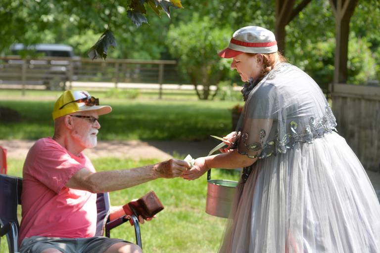 Loren Swartley of Sterling buys Oregon Ganymede base ball cards from Ganymede "super fan" Mikki Heng of Oregon during the team's game with the DuPage Plowboys on Saturday, June 3, at the John Deere Historic Site in Grand Detour. The game was played with 1858 rules which included no mitts, no called strikes or balls, and cloth bases. A crowd of around 200 people watched the 9-inning game 90-degree temperatures.