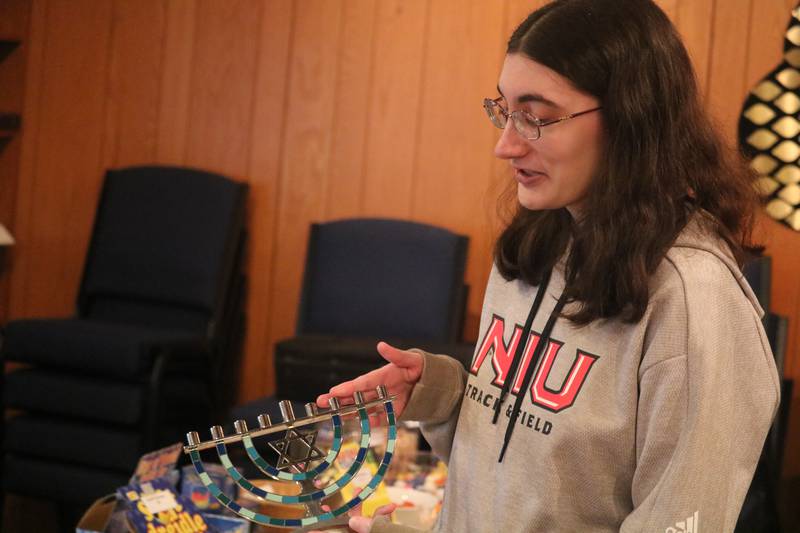 DeKalb resident Caitlin Gorman sets up a menorah in commemoration of Hanukkah on Dec. 3, 2023, at Congregation Beth Shalom in DeKalb.