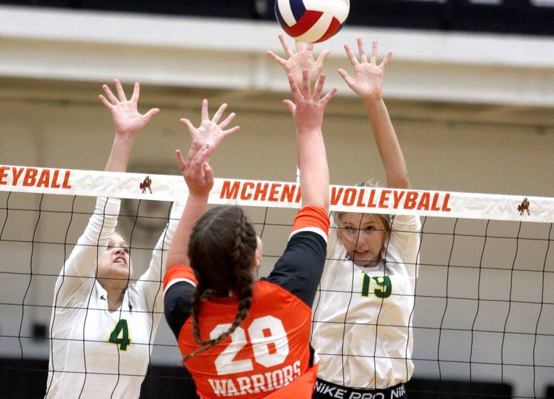 Crystal Lake South’s Bella Toniolo, left, and Logan Georgy, right, block against McHenry’s Erin Nothdorf in varsity volleyball at McHenry Tuesday night.