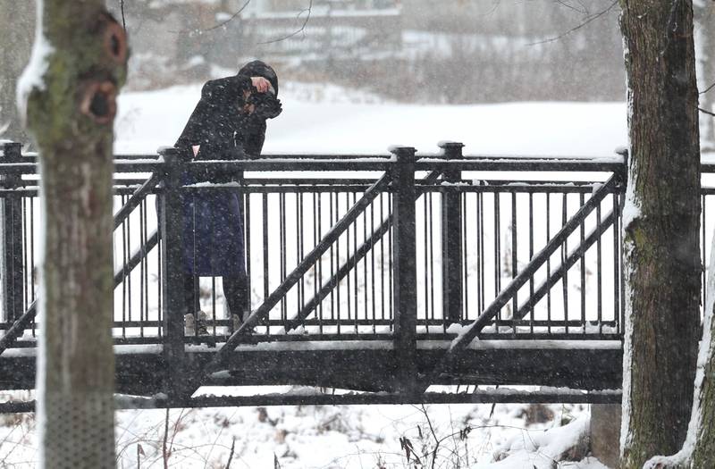 Joy Smart, from Kirkland, takes photos of the snowy landscape Tuesday, Jan. 9, 2024, near the Lagoon at Northern Illinois University in DeKalb. Several inches of heavy, wet snow Tuesday was a headache for some and fun for others.