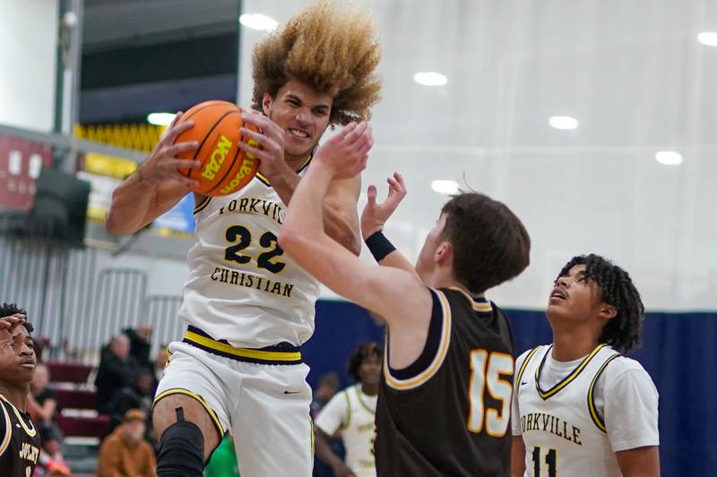 Yorkville Christian's Noah Aguado (22) rebounds the ball against Joliet Catholic's Brady Tunkel (15) during a basketball game at Yorkville Christian High School on Monday, January 13, 2025.