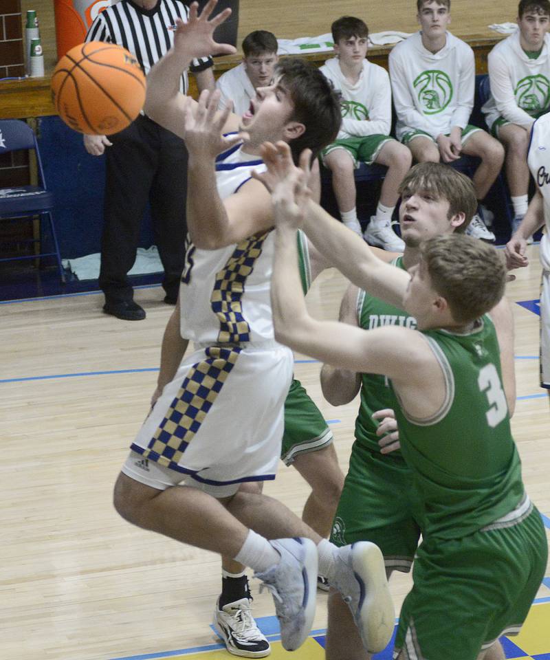 Marquette’s Alec Novotney goes to grab his own rebound ahead of Dwight’s Collin Bachand in the 1st period Monday at Marquette.