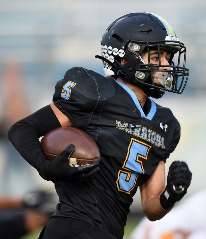 Joe Lewnard/jlewnard@dailyherald.com
Maine West’s Adam Aboebied carries the ball during Friday’s game against Schaumburg.