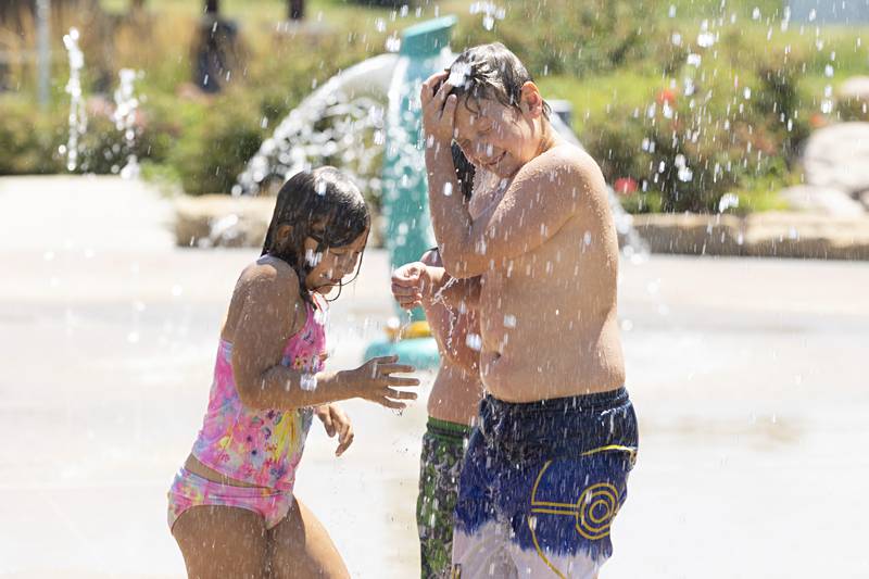 Dahlia Pels (left), 7, Alexander Rodriguez, 7, and Demitri Pels, 10, gets a cool blast of water Thursday, July 27, 2023 at the Dixon Park District splash pad. Local splash pads around the area is one of the best ways to beat the heat in the Sauk Valley.