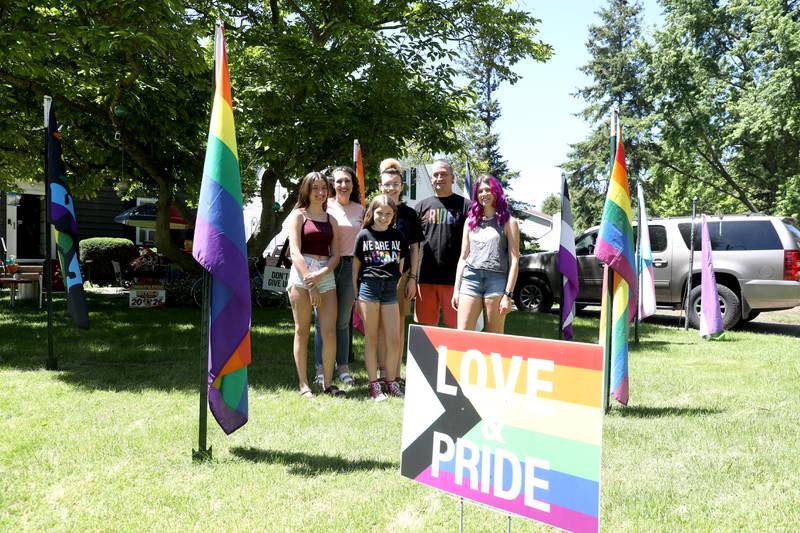 Scott and Mary Naylor and their children (from left) Ruby, 13, Fiona, 11, Lincoln, 14, and Olivia, 16, outside their Batavia home. The Naylor Family proudly display over 16 flags representing LGBTQ+ orientations and identities in their front yard.