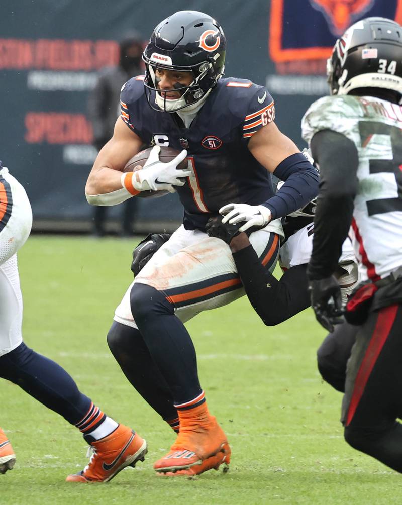 Chicago Bears quarterback Justin Fields escapes the Atlanta Falcon pass rush during their game Sunday, Dec. 31, 2023, at Soldier Field in Chicago.