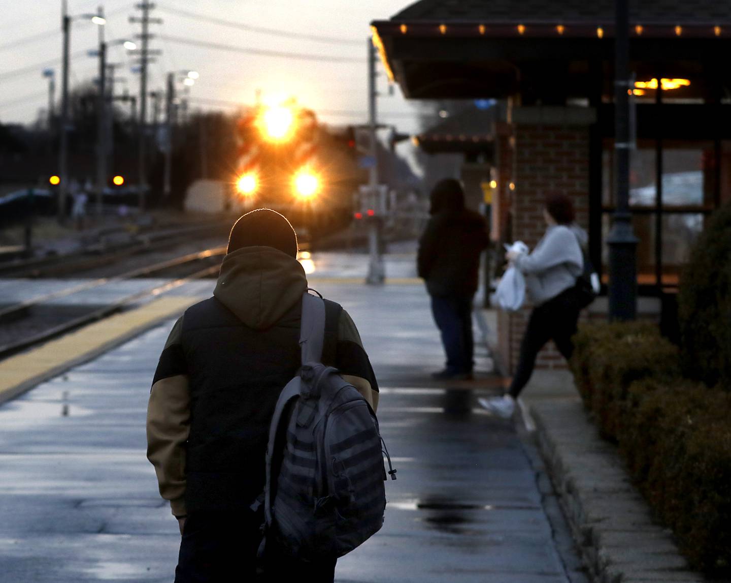 David St. Clair of Chicago and other people wait for the Metra train Tuesday, Feb. 14, 2023, at the Crystal Lake Metra station in downtown Crystal Lake.