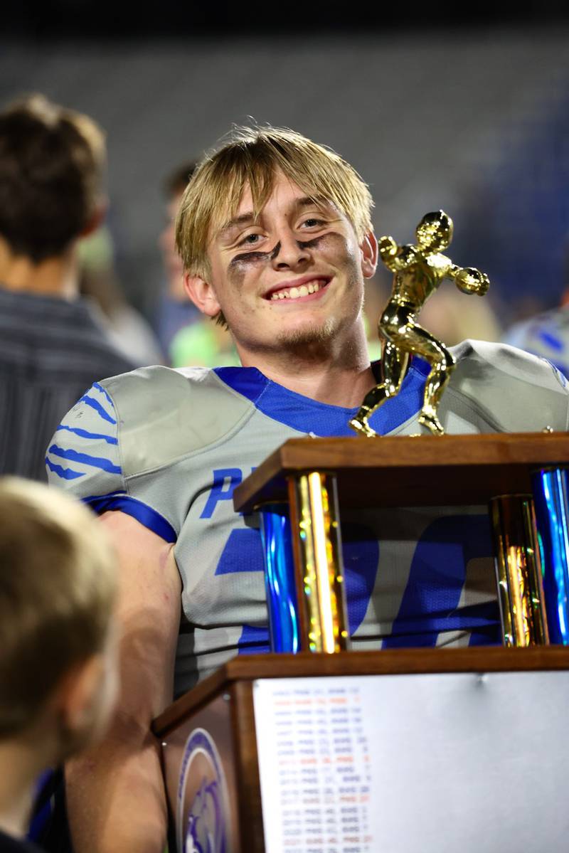 Princeton senior Common Green hoists the traveling trophy after the Tigers' 63-12 win over Kewanee on Friday.