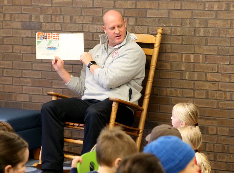 Captain Kevin Theis with the Ottawa FIre Department, reads to kids during story time on Thursday, April 10, 2025 at the Reddick Library in Ottawa.