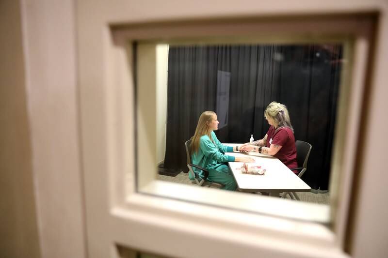 Registered Nurse Shelby Johnson gets a hand massage from Renee Larson, a licensed massage therapist, during National Nurses Week festivities at Northwestern Medicine Delnor Hospital in Geneva on Wednesday, May 10, 2023.