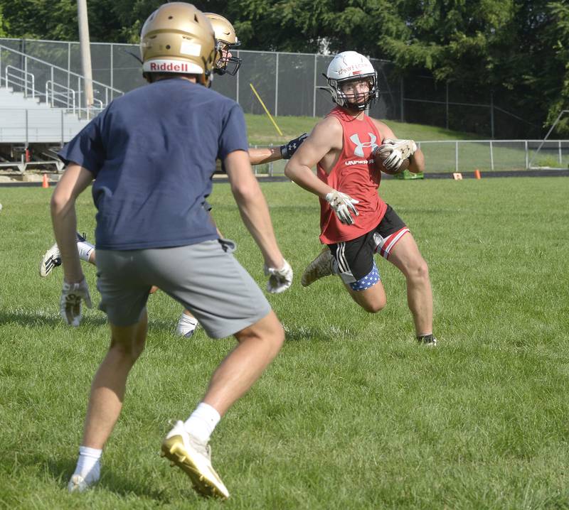 Streator ballcarrier James Pawelczyk tries to weave through the Marquette defense during the teams' joint practice/7-on-7 Monday, July 11, 2022, at the SHS Athletic Fields.