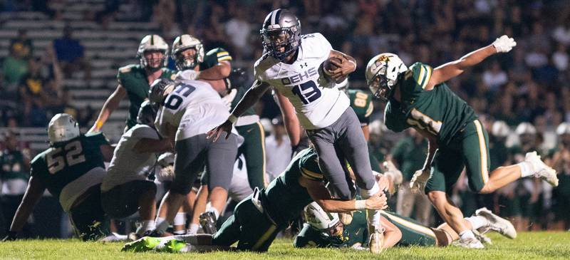 Oswego East's Jasiah Watson (13) carries the ball against Waubonsie Valley during a football game at Waubonsie Valley High School in Aurora on Friday, Aug. 25, 2023.