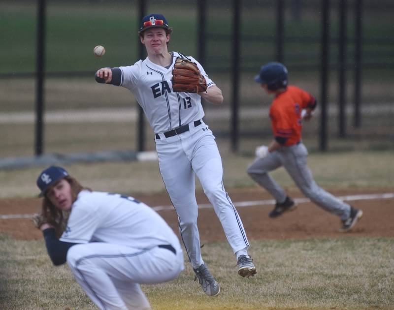 Oswego East's Joshua Polubinski (13) fields the ball and make the throw to first for a Naperville North out during Wednesday's baseball game in Naperville.