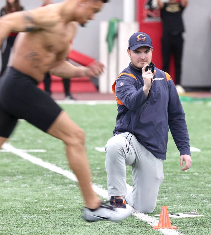 A scout from the Chicago Bears times splits during the 40-yard dash Thursday, March 23, 2023, during pro day in the Chessick Practice Center at Northern Illinois University. Several NFL teams had scouts on hand to evaluate players ahead of the upcoming draft.