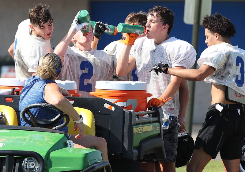 Genoa-Kingston players get hydrated on a warm afternoon Wednesday, Aug.10, 2022, during practice at the school in Genoa.