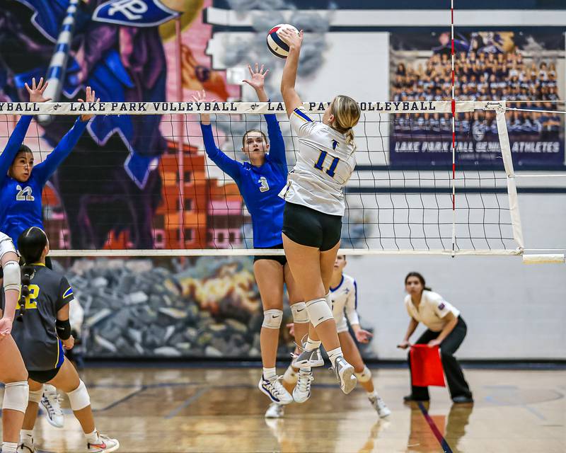 St. Charles North's Amber Czerniak (3) eyes a block attempt on Wheaton North's Ava Schell (11) spike during Class 4A Lake Park Regional final volleyball match between Wheaton North at St Charles North.  Oct 31, 2024  in Roselle.