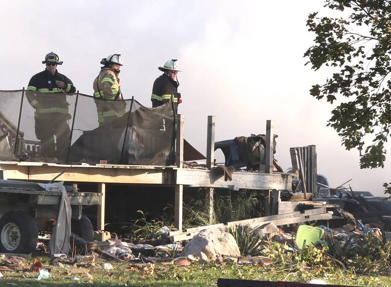 Firefighters overlook the smoldering rubble of a house Tuesday, Oct. 17, 2023, after an explosion at the residence on Goble Road in Earlville. Several fire departments responded to the incident at the single-family home that left one person hospitalized.