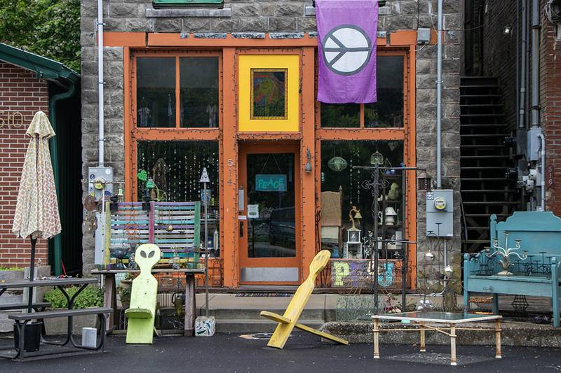 A peace sign flag hangs from the window of a storefront on the Makanda Boardwalk.