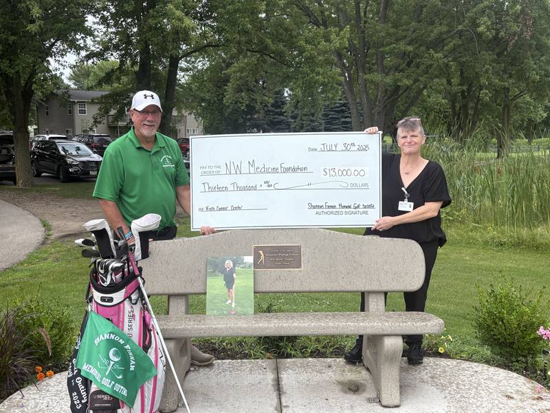 Roger Finnan (left) and Candy Domke-Hochberg of Northwestern Medicine's Cancer Center, pose with a $13,000 donation at River Heights Golf Course in DeKalb. Finnan held a charity golf outing in May 2025 in his late wife, Shannon Finnan's, honor to benefit the center where she was treated.