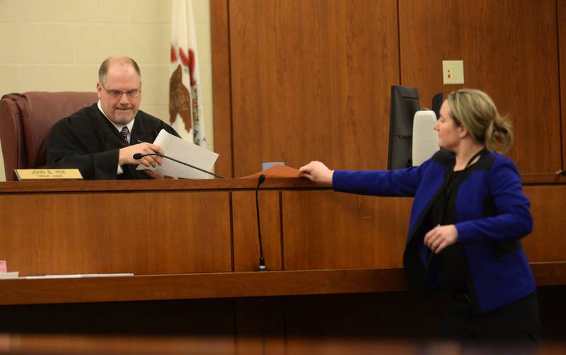 Ogle County Assistant States's Attorney Heather Kruse hands paperwork to  Judge John "Ben" Roe during Matthew Plote's pretrial release hearing on Thursday, Dec. 7, 2023.