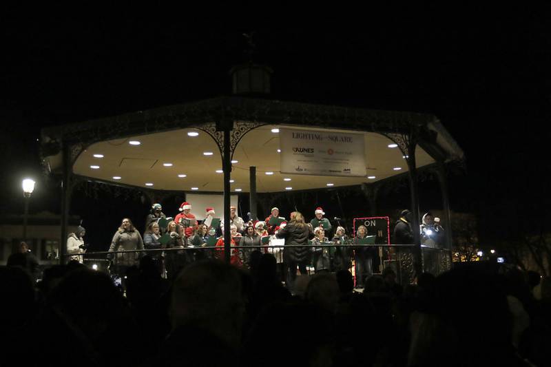 Members of the Woodstock Community Choir sing Christmas carols during the Lighting of the Square Friday, Nov. 25, 2022, in Woodstock. The annual event featured brass music, caroling, free doughnuts and cider, food trucks, festive selfie stations and shopping.