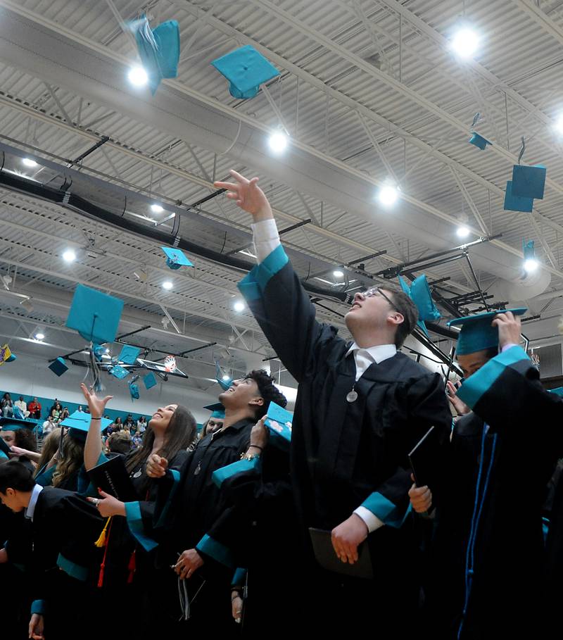 Patrick Banach and other graduates toss their caps into the air Saturday, May 14, 2022, during the graduation ceremony at Woodstock North High School.