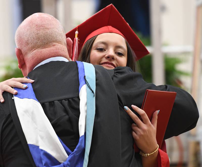 Oregon High School graduate Avery Kitzmiller hugs Assistant Principal Kip Crandall during the Class of 2026 commencement ceremony at the Blackhawk Center in Oregon on Sunday, May 24, 2026.