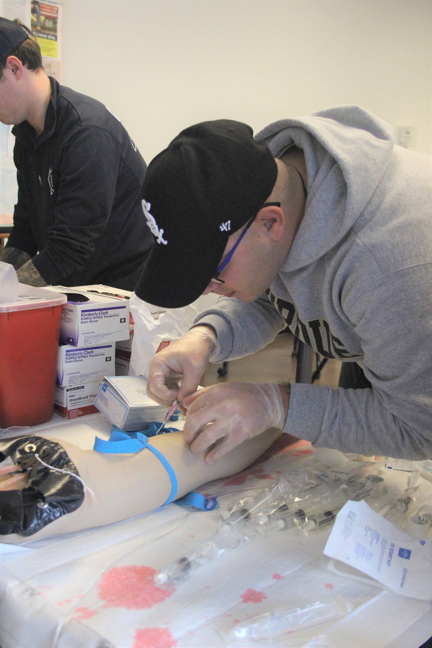 Illinois Valley Community College EMS student Clayton Wellenreiter practices starting IVs on a practice pad.