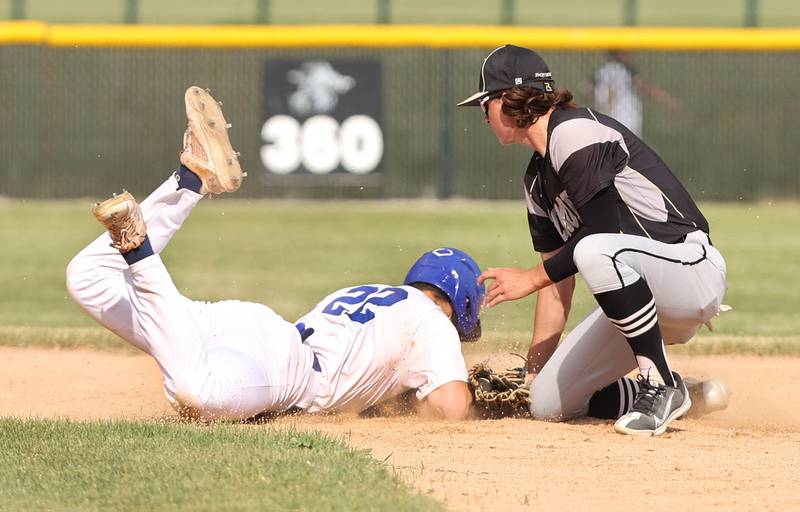 St. Francis' Peter Lemke dives back safely after a pickoff attempt at second base as Sycamore's Collin Severson applies the tag during their Class 3A regional semifinal Thursday, June 1, 2023, at Kaneland High School in Maple Park.