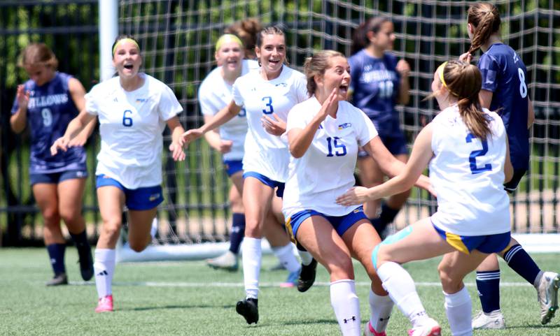 Johnsburg’s players rush to greet Devynn Michel (2) after her goal tied the score in OT against Willows Academy in IHSA Class 1A Supersectional soccer action at Dominican University in River Forest on Saturday, May 31, 2025.