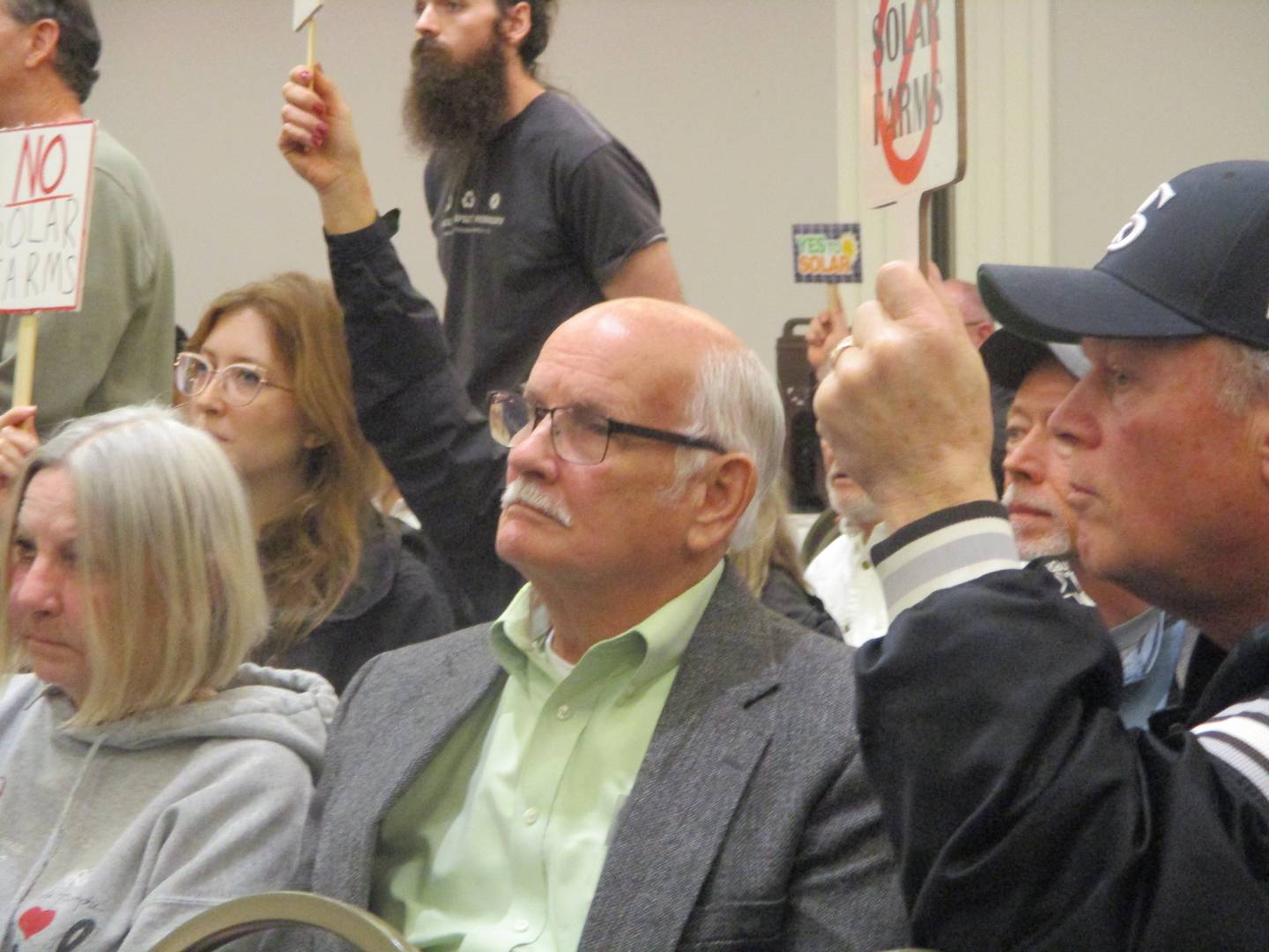 Bill Wagner, former Green Garden Township trustee, sits with solar farm opponents on Thursday at the Will County Board meeting in Joliet. April 16, 2026