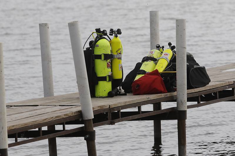 Air tanks on the dock as divers from the Antioch Fire Protection District and a sonar team from the Illinois Department of Natural Resources continue searching Tuesday, Oct. 7, 2025, on Fox Lake near Antioch for a man thrown from a boat he was test driving Monday night.