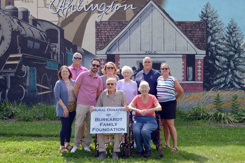 The William and Beverly Burkardt Family Foundation funded the mural painted at Louise A. Quick Park in Polo. A dedication took place July 29, 2024. Front row, left to right, are Pam Burkardt-Ballard, artist Nick Gjonola, Bill Burkardt and Polo Historical Society Director Betty Obendorf. Back row, left to right, are Mike Faivre, Paula Burkardt-Faivre, Beverly Burkardt, Polo Mayor Doug Knapp and Patti Burkardt-Brewer.