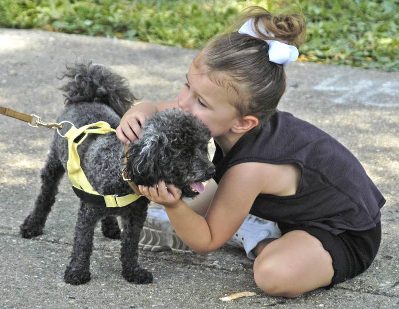Violet Renner of Dixon hugs Bodie before the dog parade in Dixon on Saturday, July 5.
