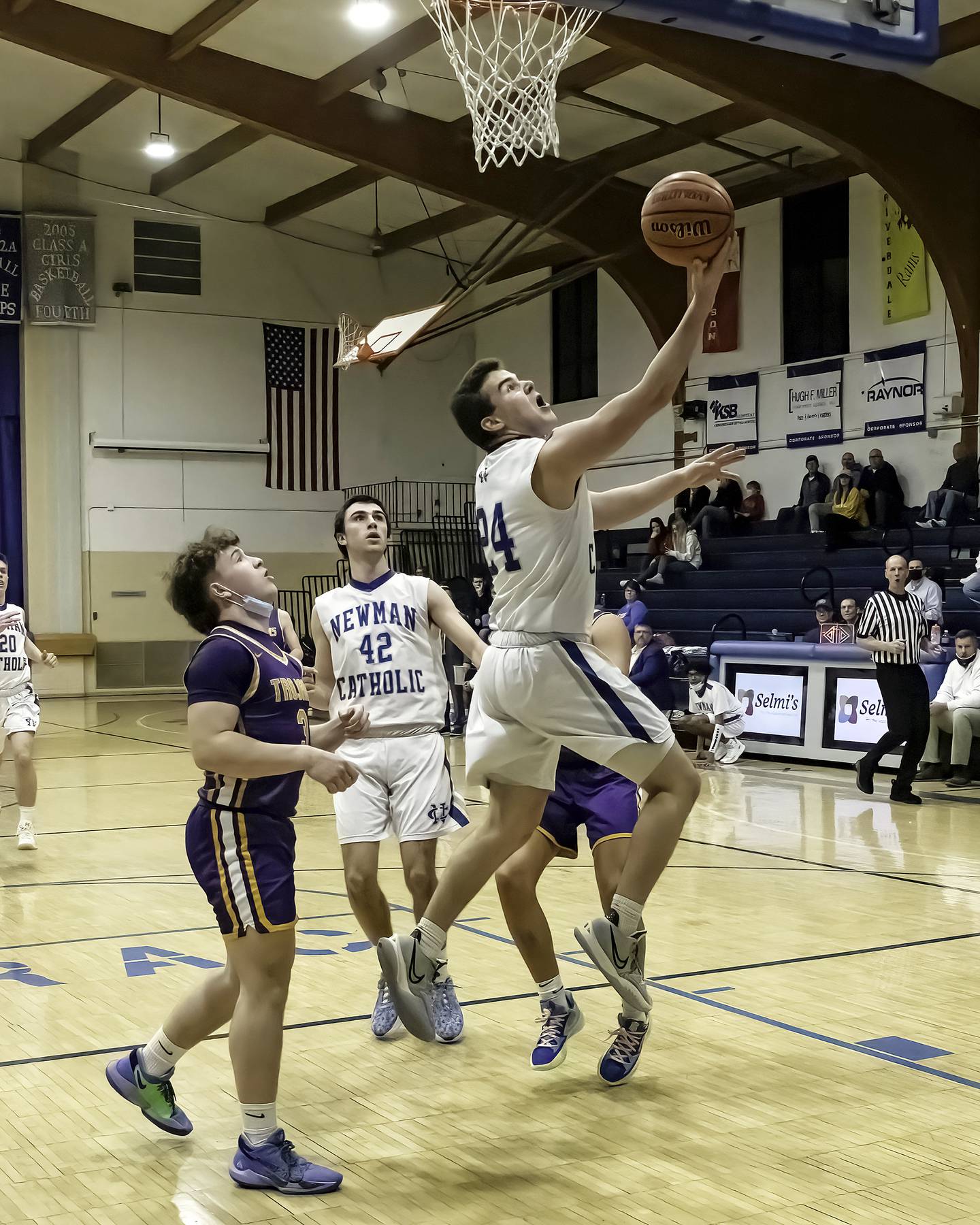 Newman's Ethan Van Landuit (24) shoots a reverse layup as teammate Jacob Donald (42) and Mendota's Krew Bond look on during their Three Rivers East game Friday night in Sterling.
