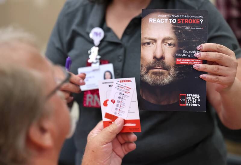 A vendor passes out information to an attendee during a senior health fair Wednesday, July 12, 2023, at DeKalb High School.